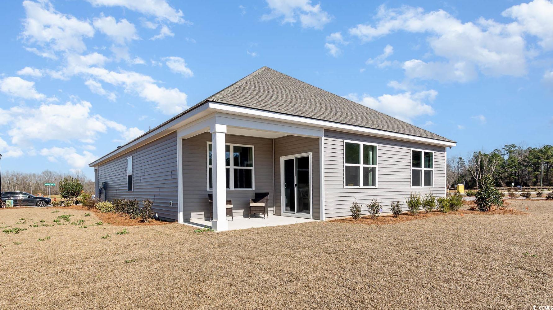 7351 Meadow Walk Loop Loris, SC 29569 - Photo 14 of 14 Rear view of house featuring a yard, a patio, and