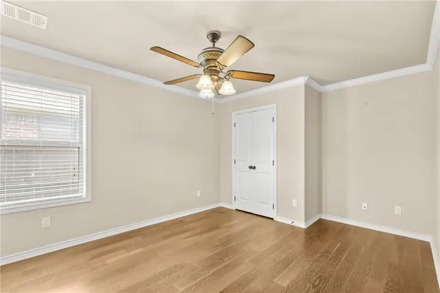 a view of an empty room with window and wooden floor