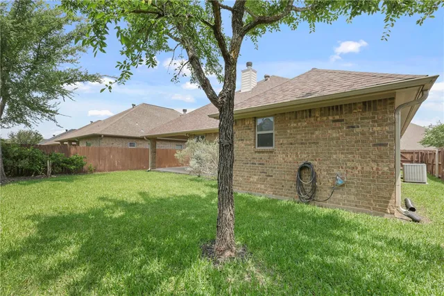 a backyard of a house with table and chairs