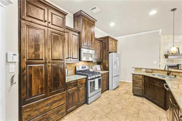 a kitchen with stainless steel appliances granite countertop a stove and a refrigerator