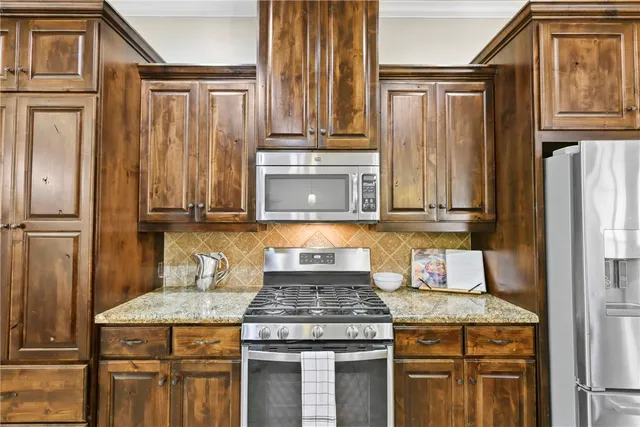 a kitchen with granite countertop cabinets stainless steel appliances and a window