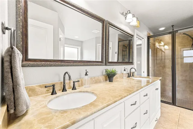 a bathroom with a granite countertop sink double and mirror