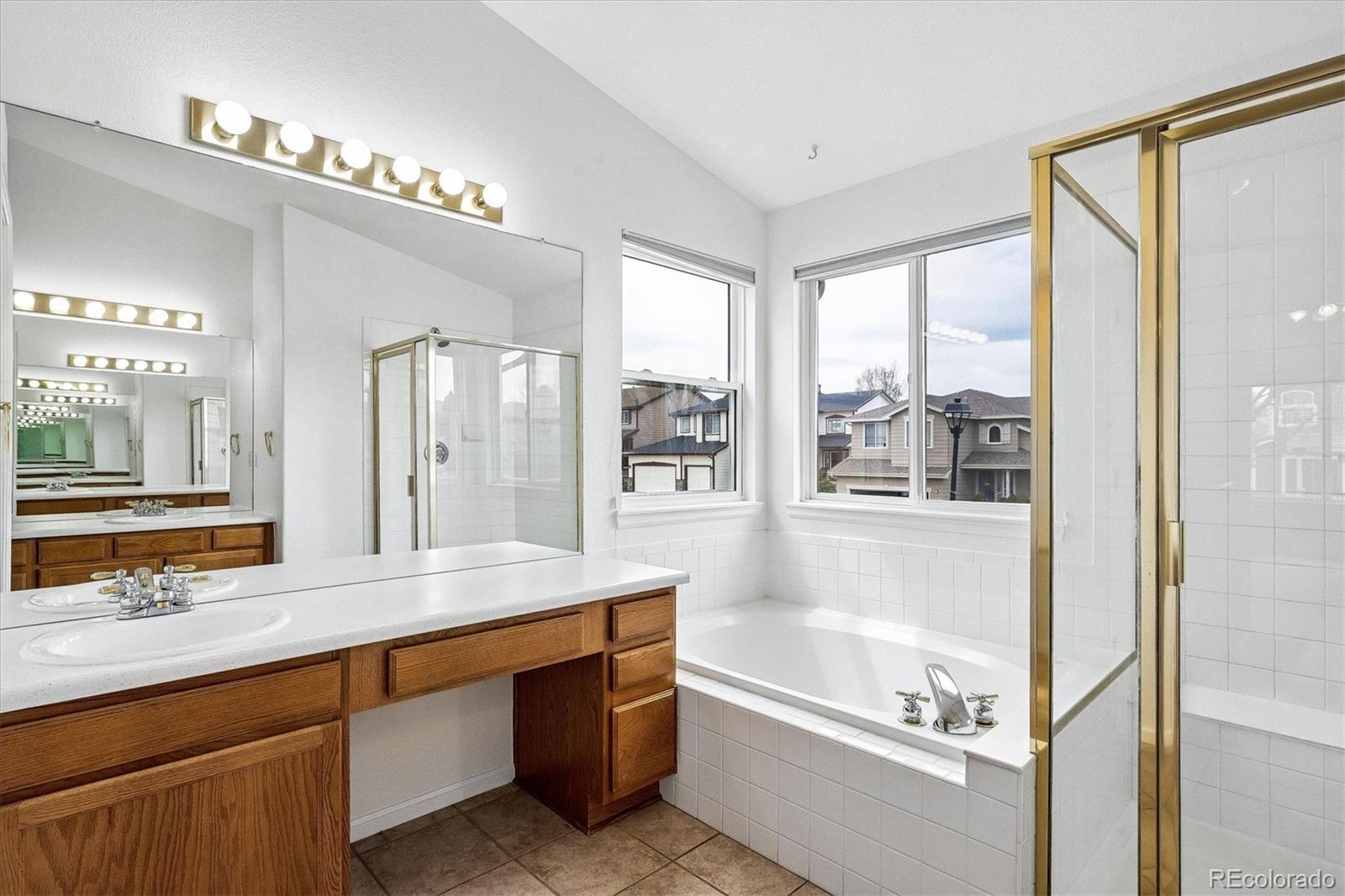 6299 Shannon Trail Highlands Ranch, CO 80130 - Photo 19 of 40 a bathroom with a tub a sink and a large mirror