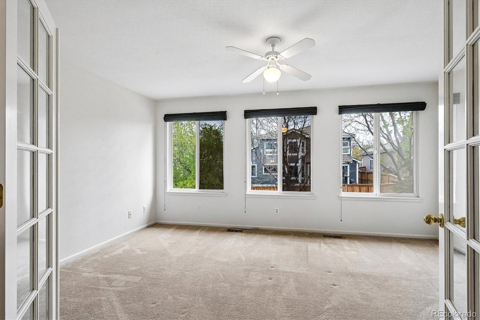 6299 Shannon Trail Highlands Ranch, CO 80130 - Photo 22 of 40 an empty room with windows and chandelier fan