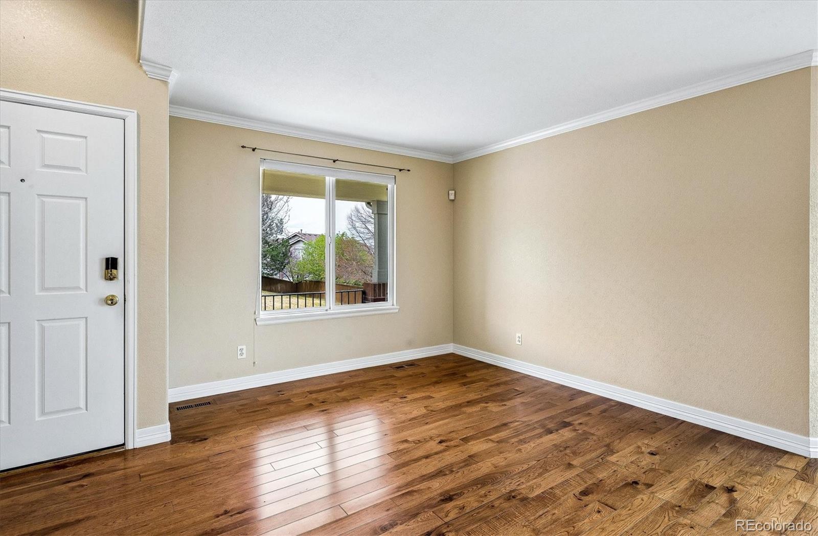 6299 Shannon Trail Highlands Ranch, CO 80130 - Photo 4 of 40 a view of an empty room with wooden floor and a window