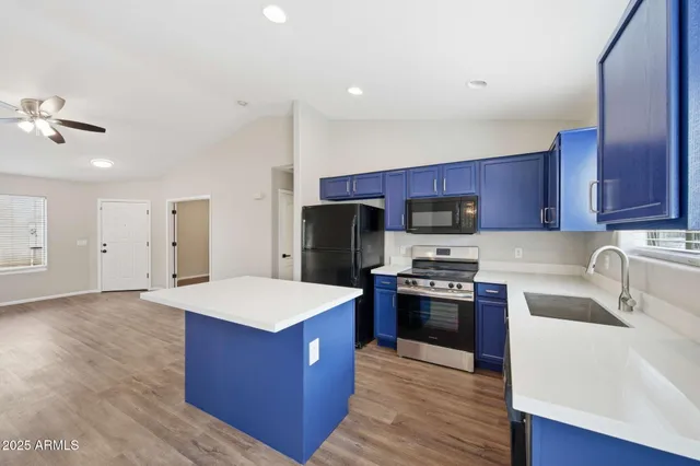 a kitchen with stainless steel appliances granite countertop a stove a sink dishwasher a refrigerator and a oven with wooden floor