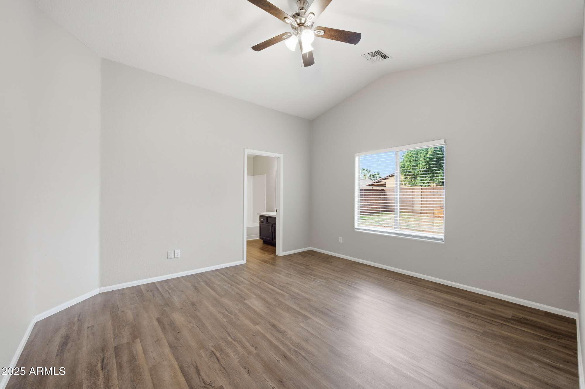4128 East Copper Road San Tan Valley, AZ 85143 - Photo 13 of 27 an empty room with wooden floor chandelier fan and windows