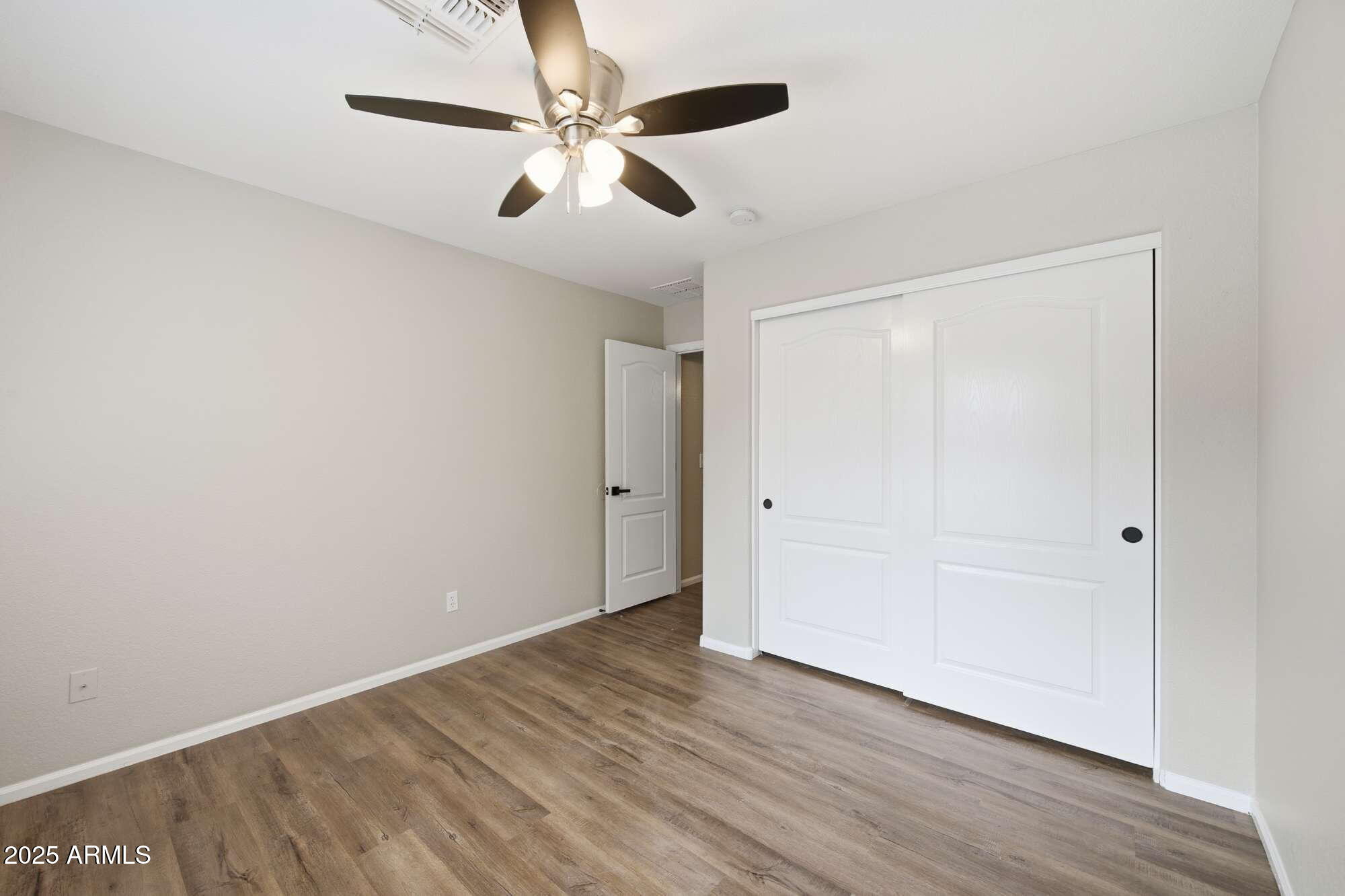 4128 East Copper Road San Tan Valley, AZ 85143 - Photo 21 of 27 an empty room with wooden floor fan and windows