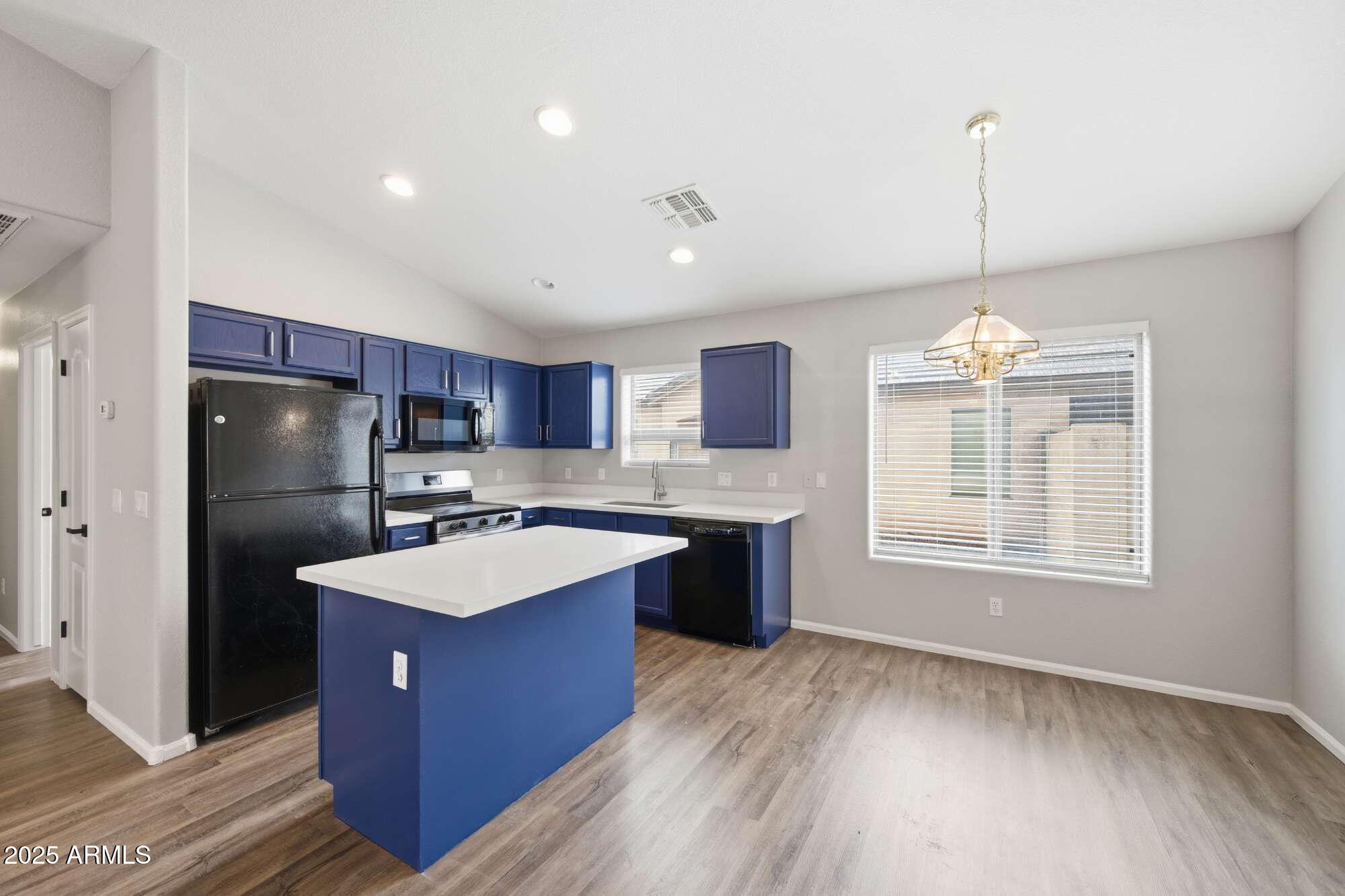 4128 East Copper Road San Tan Valley, AZ 85143 - Photo 9 of 27 a kitchen with kitchen island granite countertop a sink refrigerator and wooden floor