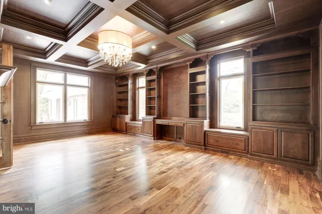 a view of a livingroom with a fireplace a chandelier and wooden floor