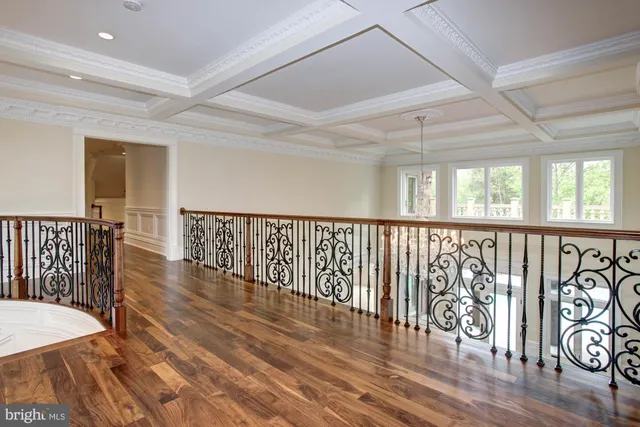 a view of a hallway with wooden floor and stairs