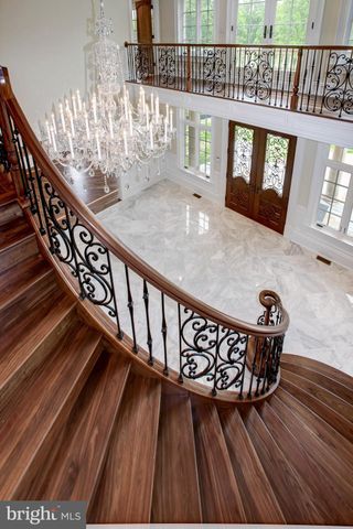 a view of an empty room with wooden floor and chandelier