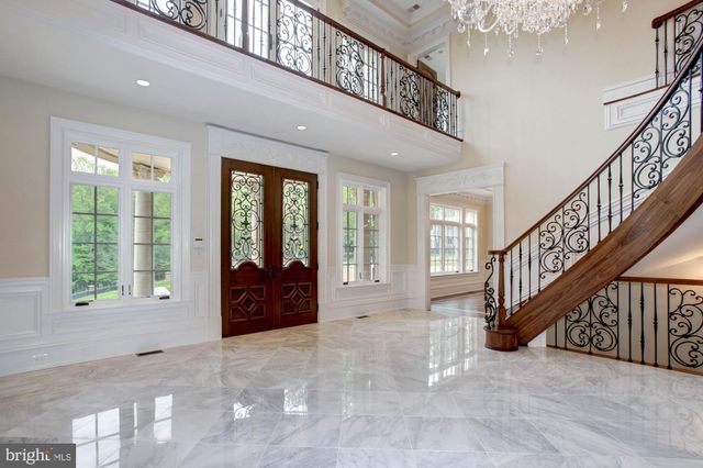 a view of an empty room with wooden floor a fireplace and a window