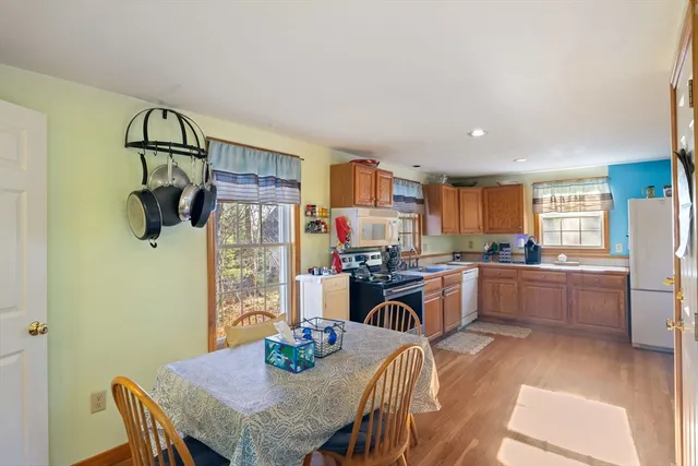 a kitchen with stainless steel appliances granite countertop a kitchen island a stove a table and chairs