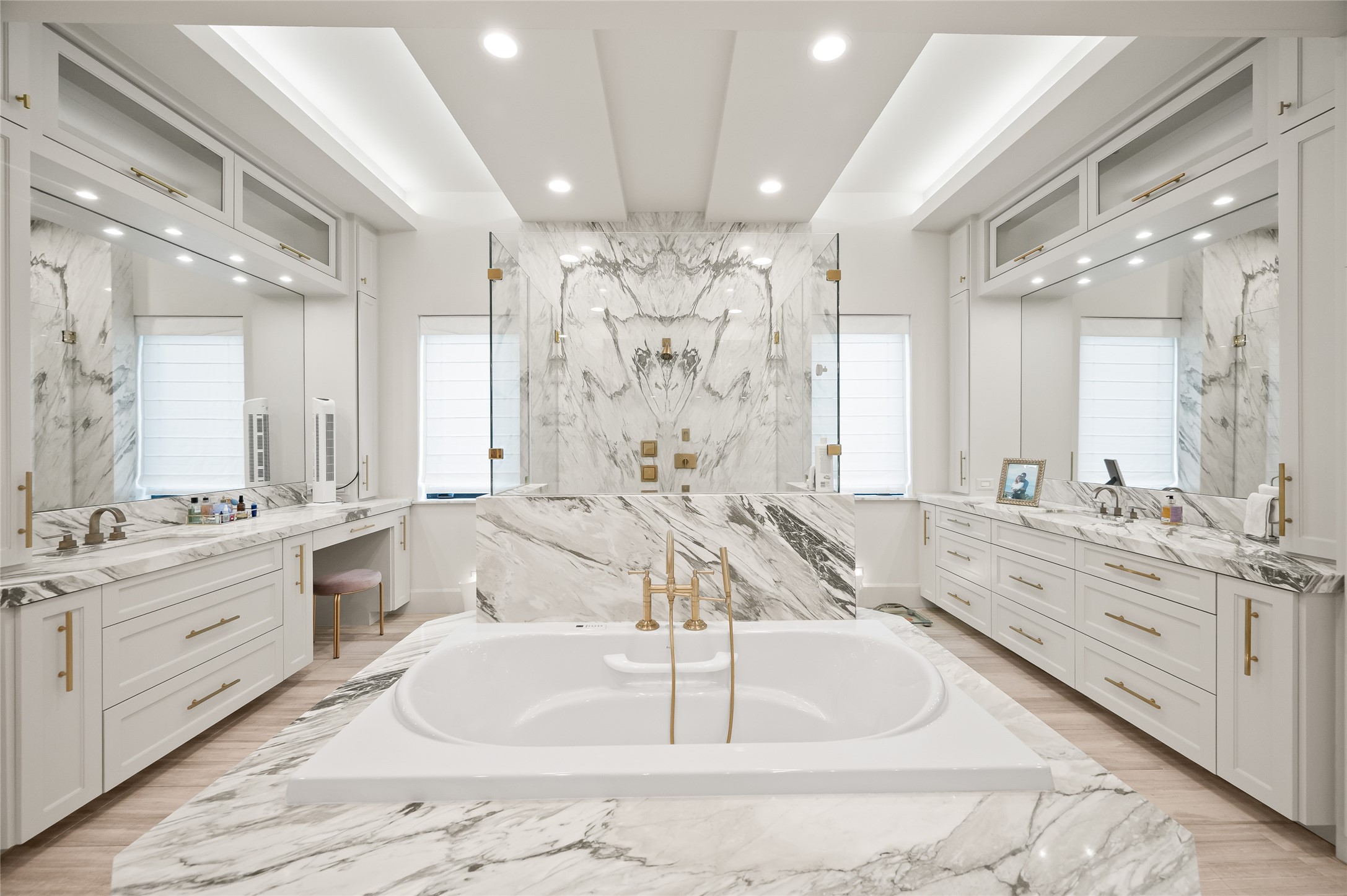 11518 Shadow Way Street Houston, TX 77024 - Photo 21 of 50 The primary suite bath offers marble The primary bath is a spa-inspired haven with marble finishes, a jetted tub, glass shower, and a designated vanity area. Designed for both luxury and practicality, it provides abundant space and storage.