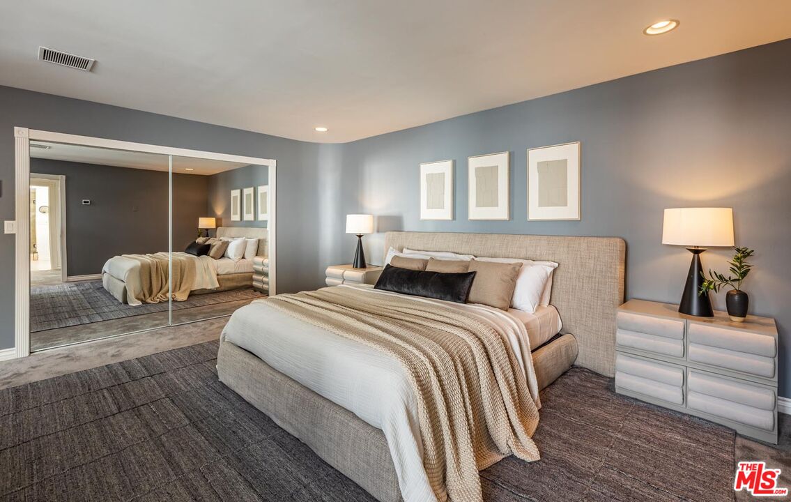 1501 Rising Glen Road Los Angeles, CA 90069 - Photo 8 of 17 a spacious bedroom with a bed and wooden floor