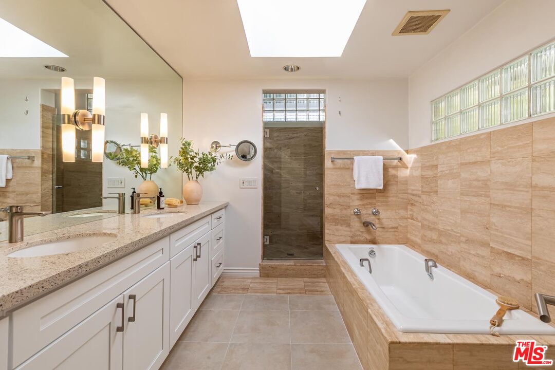 1501 Rising Glen Road Los Angeles, CA 90069 - Photo 10 of 17 a spacious bathroom with a granite countertop tub sink shower and mirror