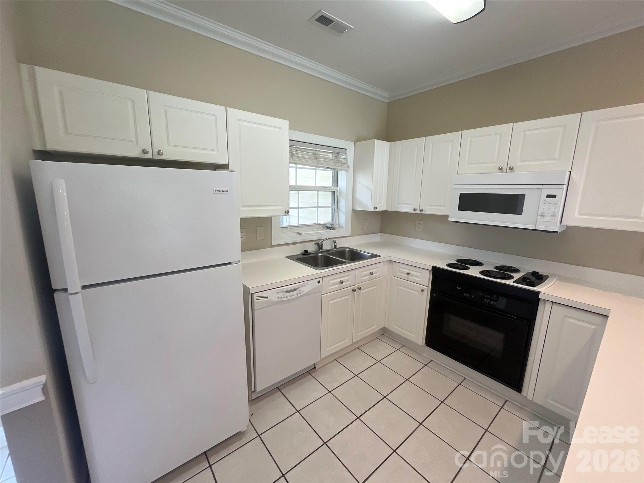 8913 Meadow Vista Road Charlotte, NC 28213 - Photo 4 of 17 a kitchen with a refrigerator sink and cabinets