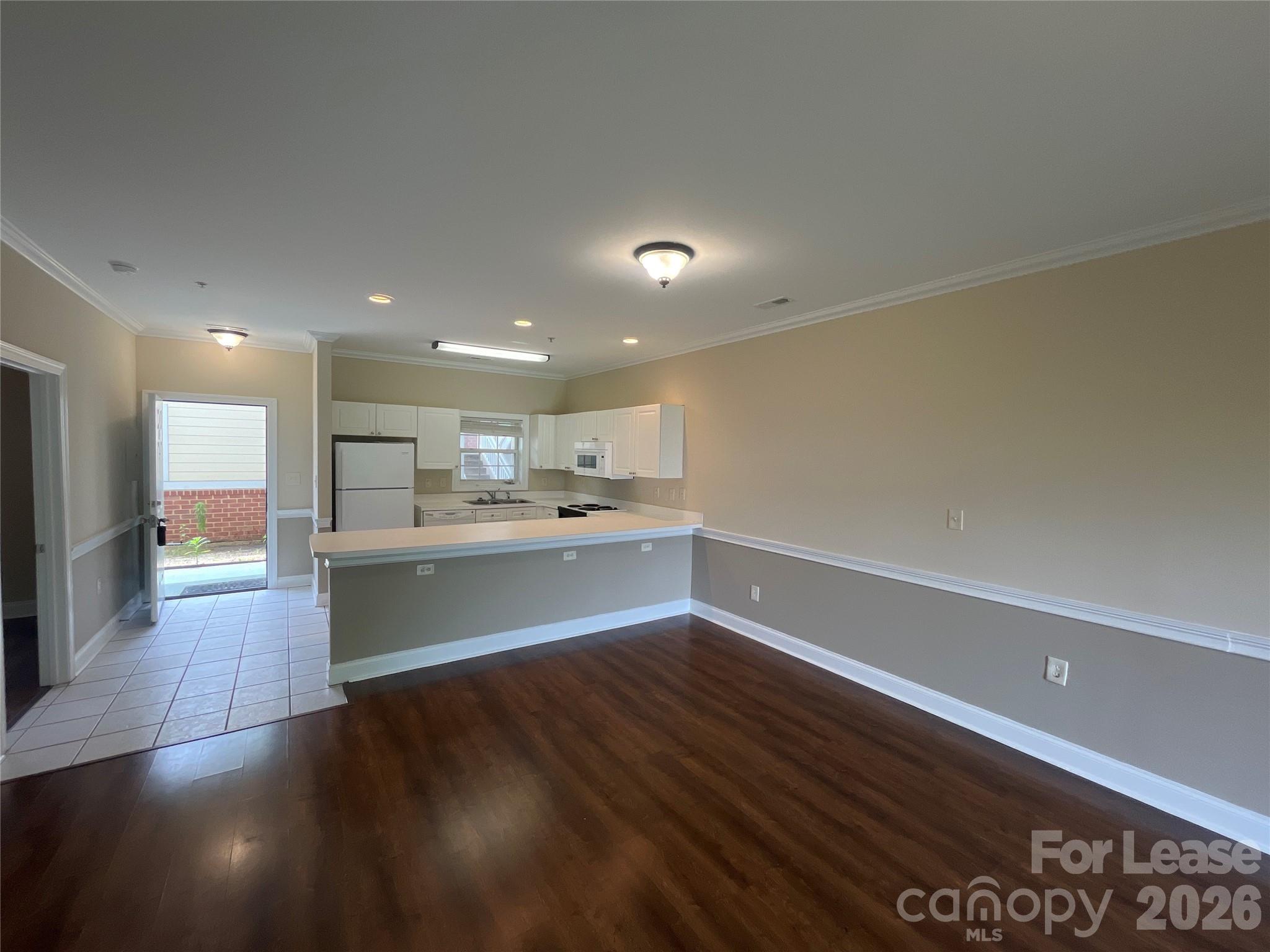 8913 Meadow Vista Road Charlotte, NC 28213 - Photo 7 of 17 a view of a kitchen with kitchen island a sink wooden floor and a counter top space