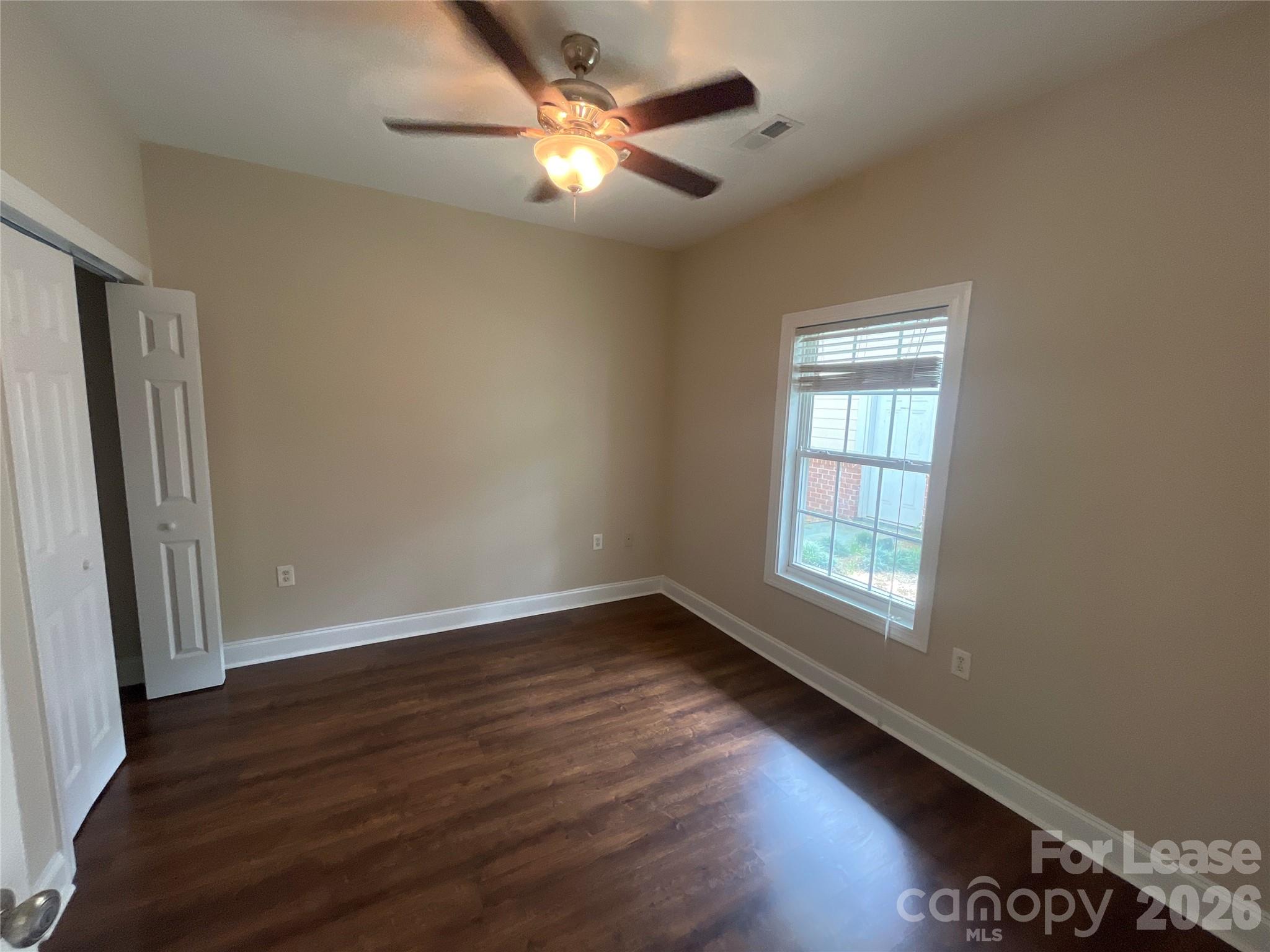 8913 Meadow Vista Road Charlotte, NC 28213 - Photo 10 of 17 an empty room with wooden floor fan and windows