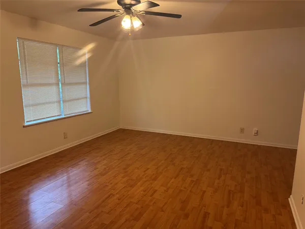 an empty room with a window and wooden floor
