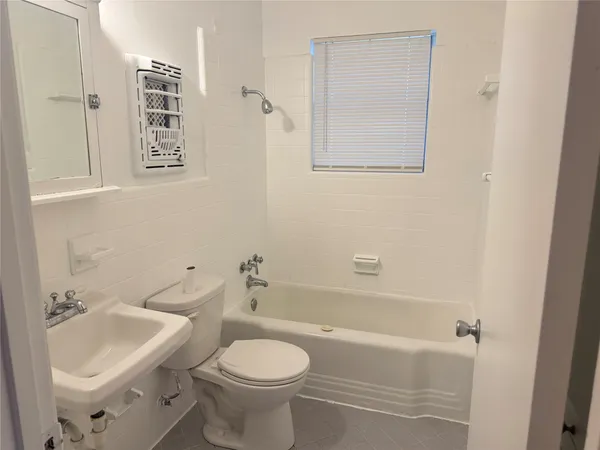 a bath room with a toilet a sink and a bath tub