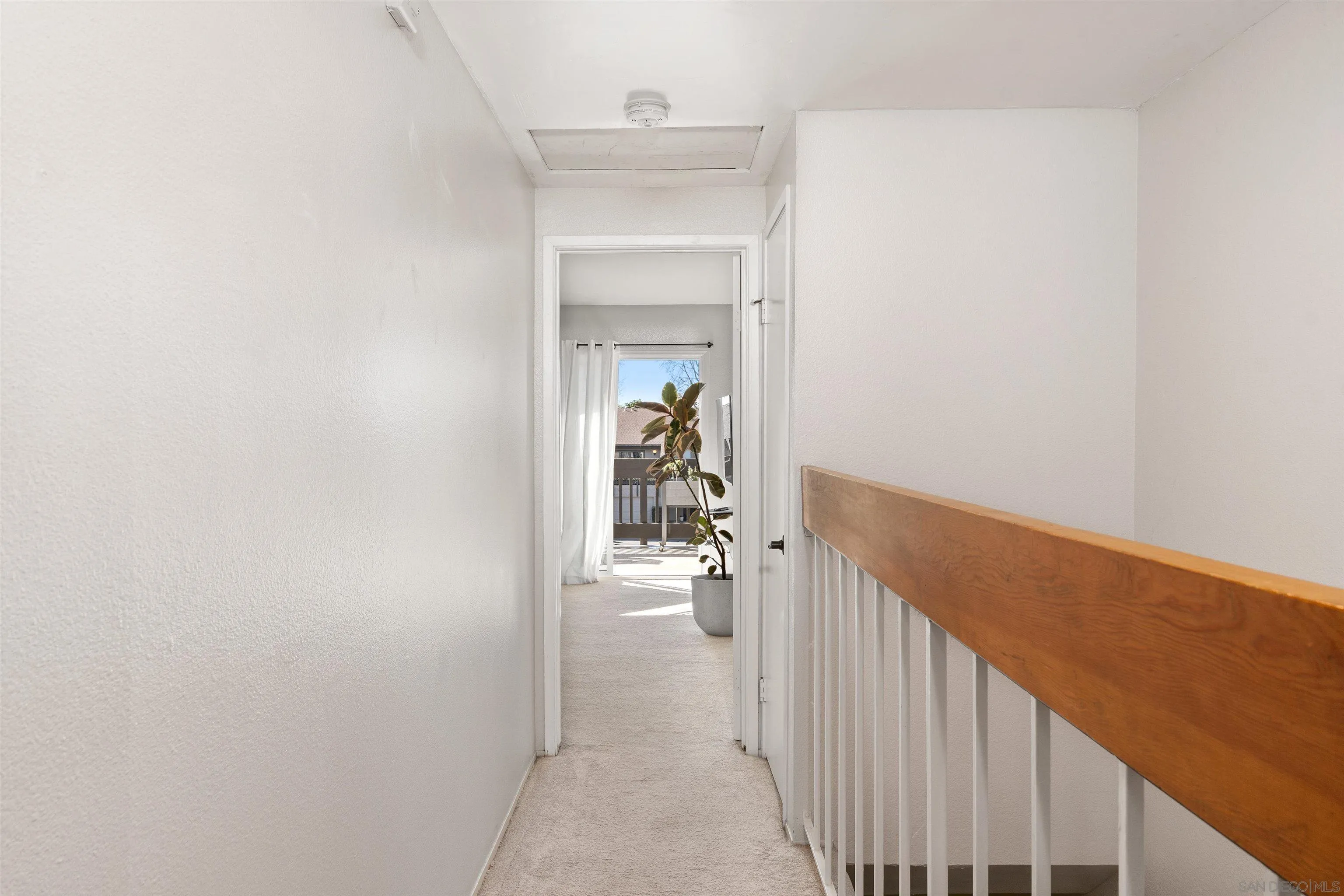 8366 Via Sonoma, Unit D La Jolla, CA 92037 - Photo 16 of 43 a view of a hallway with wooden floor and staircase