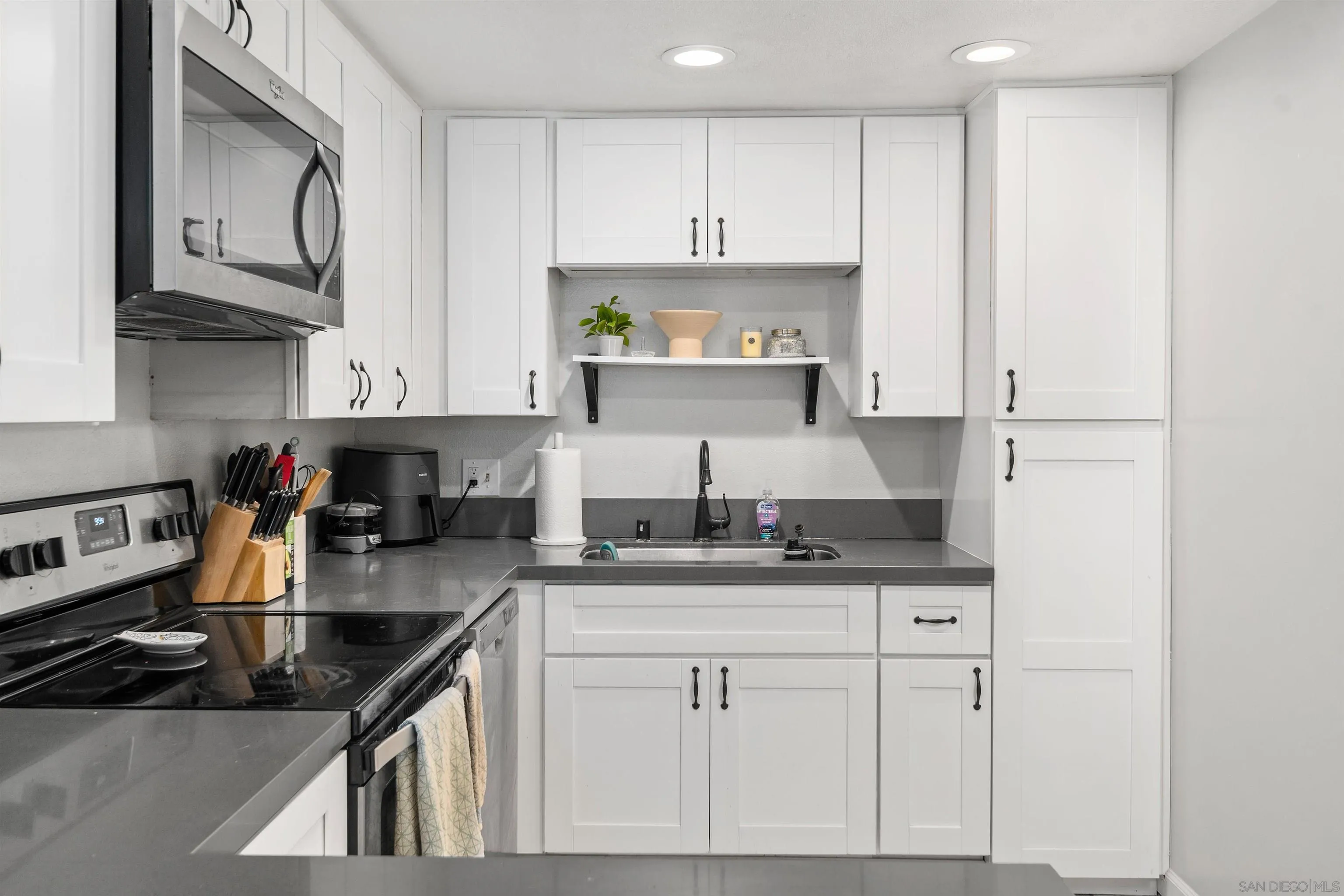8366 Via Sonoma, Unit D La Jolla, CA 92037 - Photo 8 of 43 a kitchen with granite countertop a sink a stove and cabinets