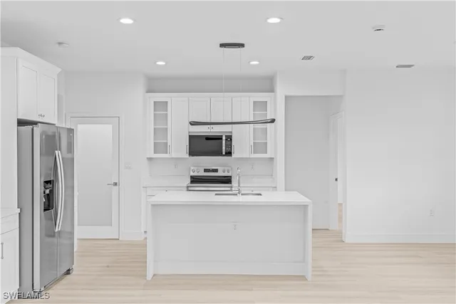 a view of kitchen with stainless steel appliances cabinets