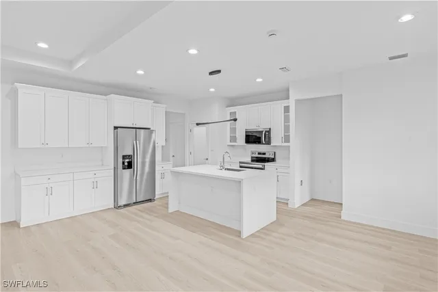a kitchen with white cabinets and stainless steel appliances