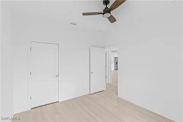 an empty room with a window and a ceiling fan