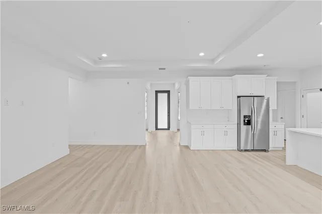 a view of empty room with wooden floor and window