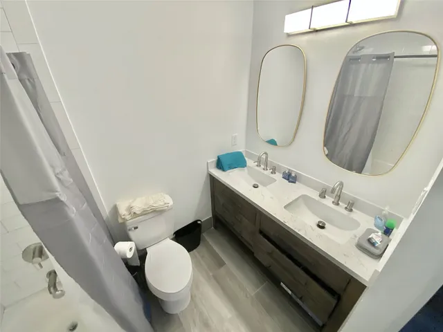 a bathroom with a double vanity sink mirror and toilet