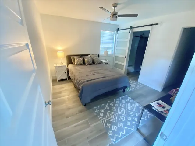 a bedroom with a bed rug and wooden floor