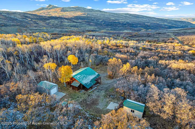 an aerial view of a house with a yard and swimming pool