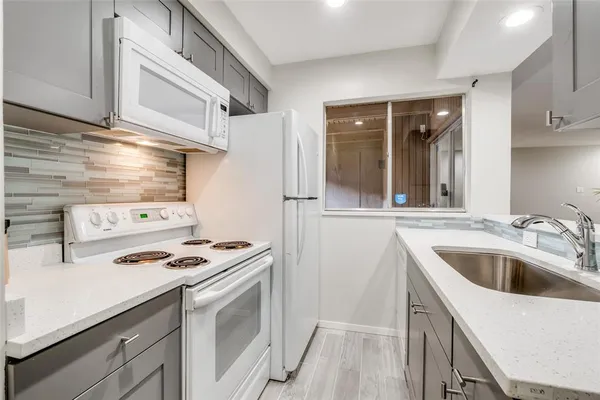 a kitchen with stainless steel appliances granite countertop a sink and a stove