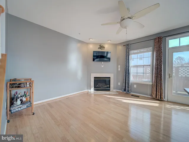 a view of an empty room with kitchen and a window