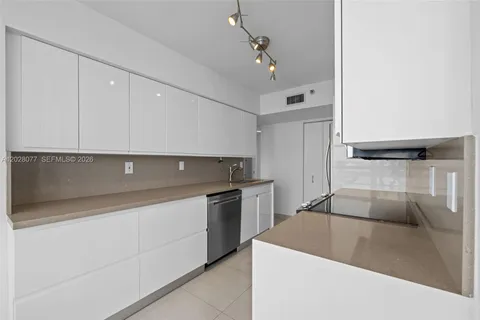 a kitchen with a sink and stainless steel appliances
