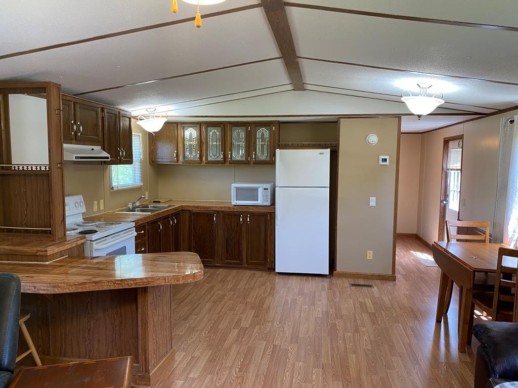 313 Lonesome Pine Road Bybee, TN 37713 - Photo 14 of 48 a kitchen with kitchen island stainless steel appliances a table chairs and wooden floor