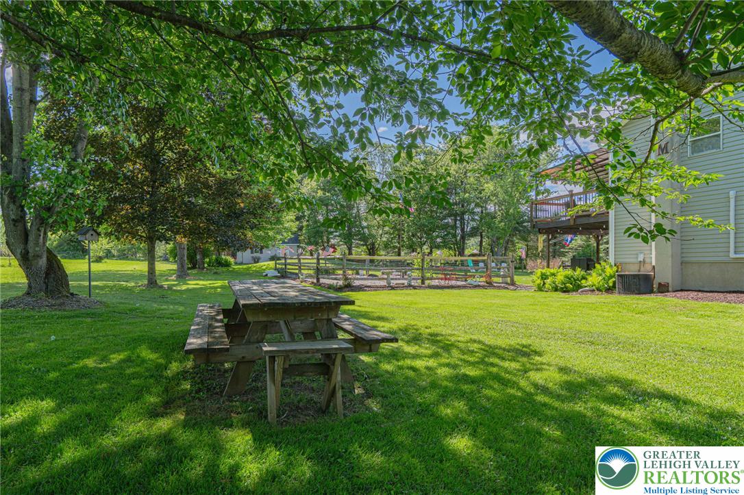 341 Lower Greenhill Road Kunkletown, PA 18058 - Photo 63 of 69 A verdant yard offers a delightful picnic area, framed by established trees and a charming split-rail fence.