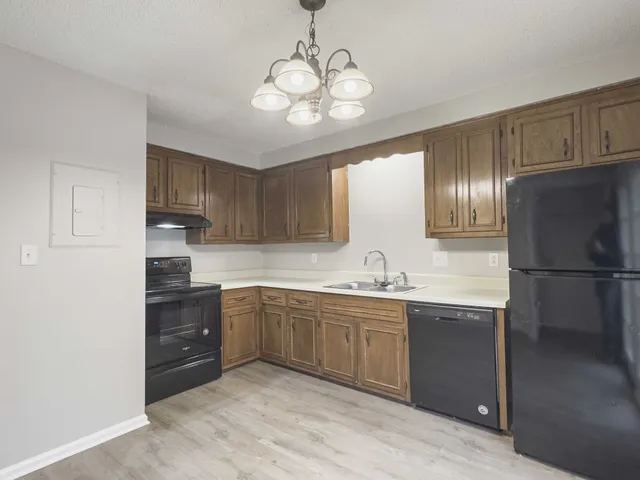a kitchen with stainless steel appliances granite countertop a sink refrigerator and cabinets