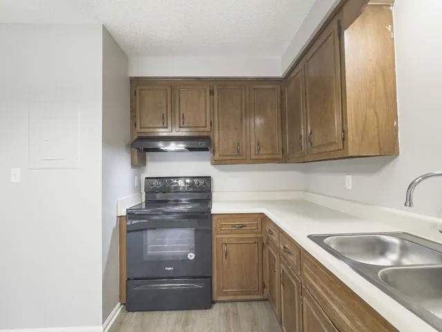 a kitchen with granite countertop a sink and a stove top oven