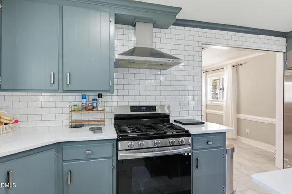 a kitchen with stainless steel appliances granite countertop a stove and a white cabinets