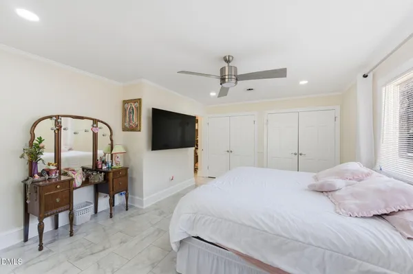 a bedroom with a bed a television and a large window