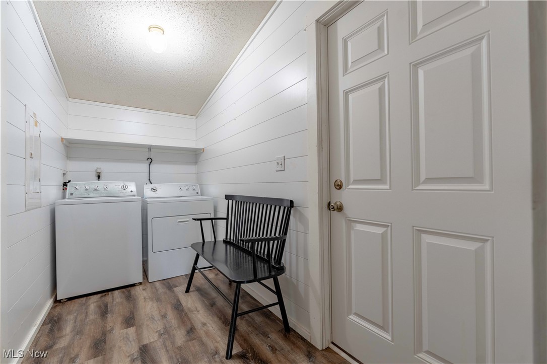 2176 Pageant Road Southeast Carrollton, OH 44615 - Photo 21 of 39 Laundry area featuring independent washer and dryer, a textured ceiling, dark wood finished floors, and wood walls