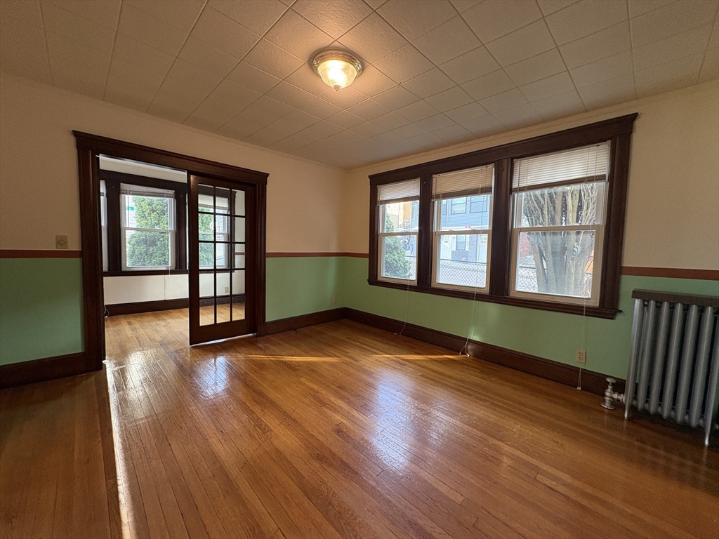 155-157 Hillside Street, Unit 1 Boston, MA 02120 - Photo 1 of 18 wooden floor in an empty room with a window