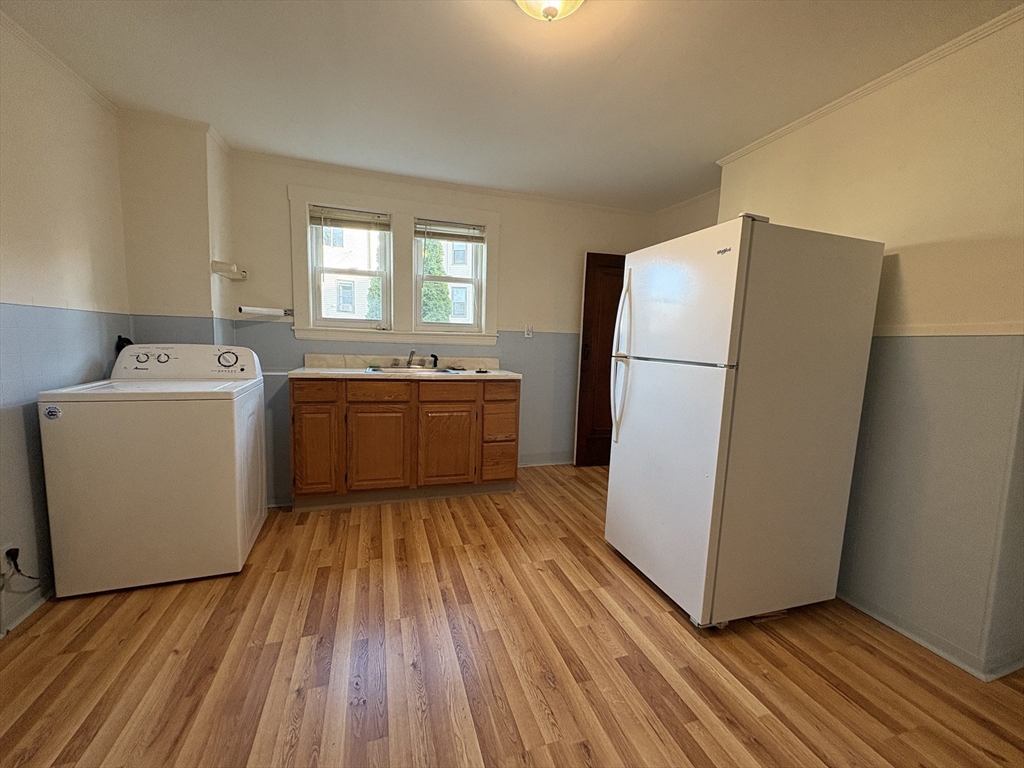155-157 Hillside Street, Unit 1 Boston, MA 02120 - Photo 17 of 18 a utility room with wooden floor washer and dryer