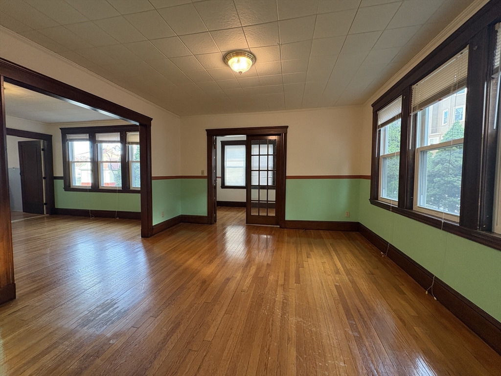155-157 Hillside Street, Unit 1 Boston, MA 02120 - Photo 3 of 18 an empty room with wooden floor and windows