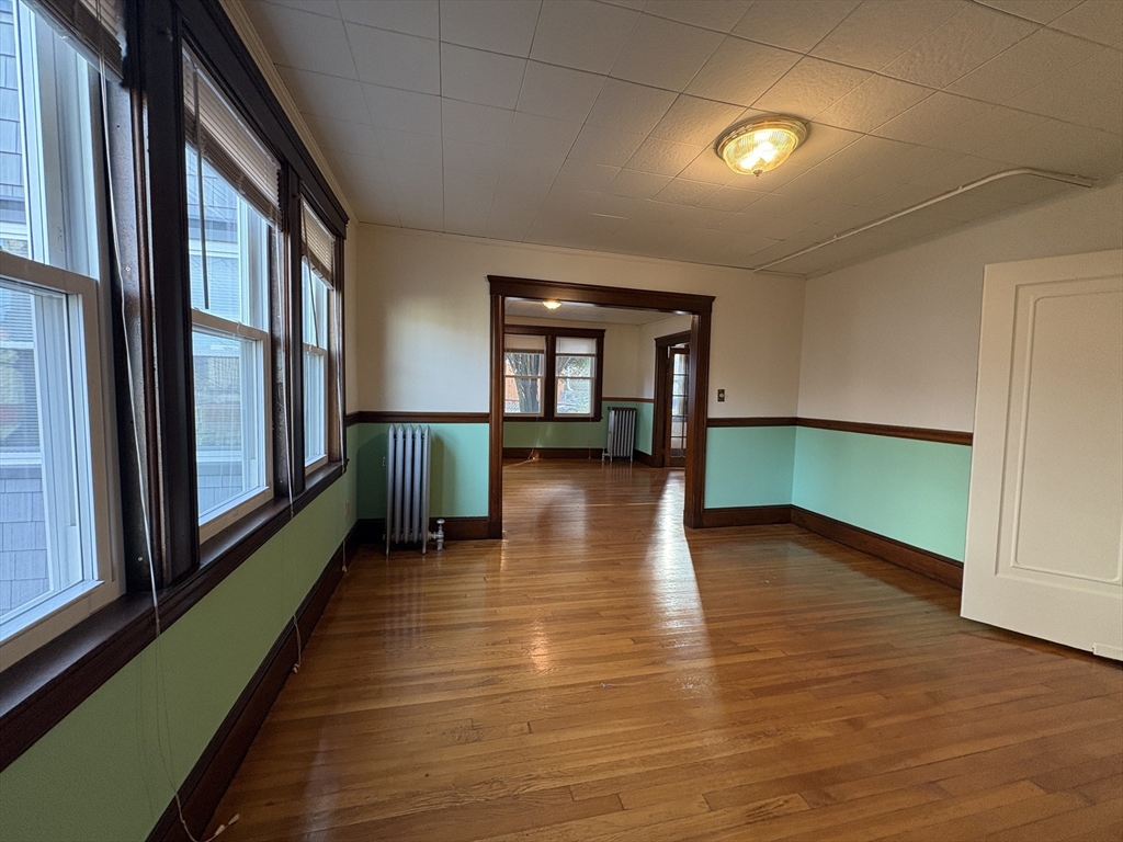 155-157 Hillside Street, Unit 1 Boston, MA 02120 - Photo 6 of 18 an empty room with wooden floor and windows