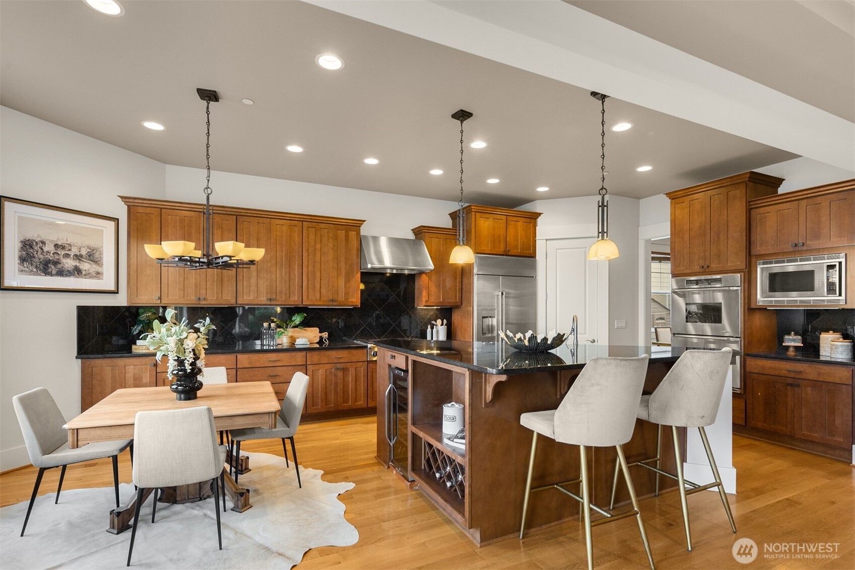 1500 South 5th Place Renton, WA 98057 - Photo 11 of 40 a kitchen with stainless steel appliances kitchen island granite countertop a table chairs and a refrigerator